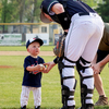 (photo by Bruce Brierley)
Senior High junior John Anderson (13) hands the ball and gets a fist pump from Dave Aker’s grandson Emmett who threw out the ceremonial first pitches.